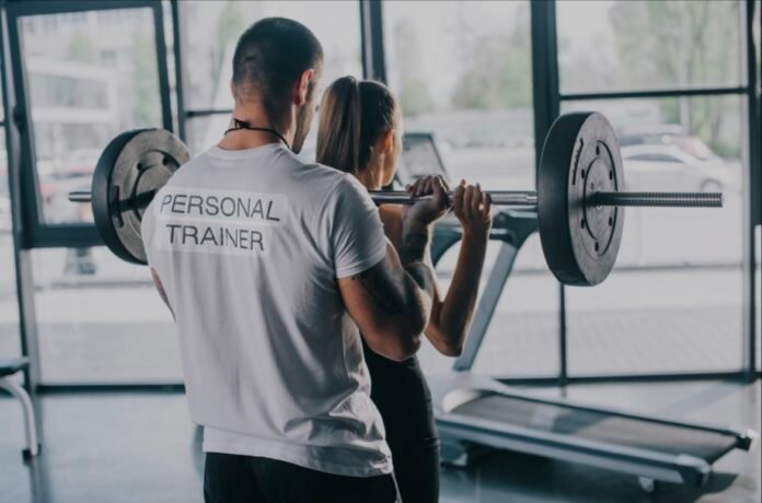 Fitness coach demonstrating a strength-based fitness routine in the gym
